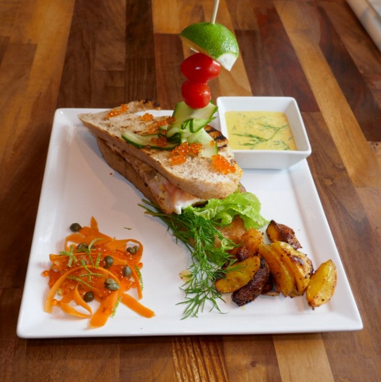Salmon sandwich with mustard sauce, pickled vegetables and boat potatoes
