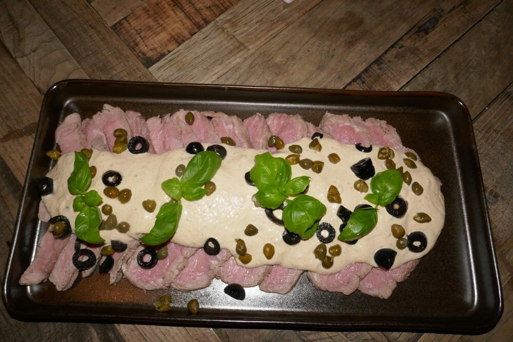 Vitello tonnato pyntet med kapers, oliven og basilikum